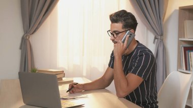 Ofis işleri. Gezici danışmanlık. Akıllı telefondan konuşan zeki bir profesyonel iş raporlarını okuyor. Bilgisayarla birlikte çalışma yerinin fotokopisini çekiyor..