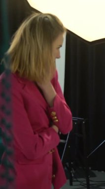 Dikey video. Sahne arkası Vogue. Moda fotoşopu. Stüdyoda profesyonel ekipman kullanan kadın model ve fotoğrafçı..