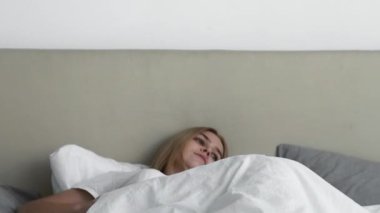 Neşeli uyanıksın. İyi uykular. Sabah rahatlığı. Mutlu sakin genç kız yatakta gerinerek gülümsüyor yeni bir güne başlıyor..