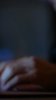 Dikey video. Ofis işi. Akşam işi. Adam klavyede yazı yazan elleri bulanıklaştırdı. Şirket iş e- postalarını karanlık çalışma masasında kopyalıyor..