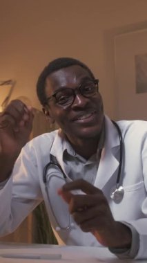 Dikey video. Doktor konferansı. Teletıp sohbeti. Muayene randevusu. Mutlu erkek doktor selamlaşıyor. Merhaba diyor. Hasta iyileşmesini tartışıyoruz..