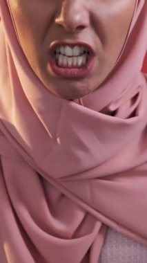 Dikey video. Öfke hüsranı. Çatışma tartışması. Sinirli, öfkeli, tesettürlü, küfürlü, öfkeyle bağıran bir kadın..