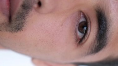Dikey video. Görüş düzeltmesi. Vizyon ilacı. Oftalmoloji kliniği. Sakin bir adam, yarım yüz portresi, sağlıklı kahverengi göz rengi..