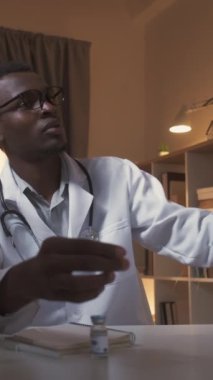 Dikey video. Akciğer taraması. Radyoloji sınavı. Covid-19 zatürree. Endişeli erkek doktor, evde çalışan göğüs röntgeni üzerinde çalışıyor..