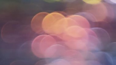 Bokeh ışıkları. Soyut pastel arkaplan. Bulanık mavi pembe turuncu daireler renk değişimi hareketi. Gece şehri ışıltısı etkisi. Yumuşak odak yanardöner desen.