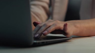 Dizüstü bilgisayar daktilosu. Online eğitim. Tanımlanamayan bir kadın bilgisayar tuşuna basarak bilgi topluyor ve öğrenci araştırmaları hakkında notlar alıyor..