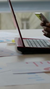 Dikey video. Dikkatlerini dağıt. Gadget bağımlılığı. Ofisteki kadın ve erkek iş arkadaşları iş yerindeki sosyal medyada dizüstü bilgisayarla yazı yazma ve molada belge yazma işlerini hallediyorlar..