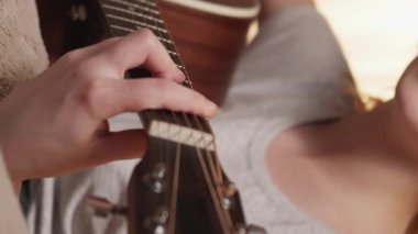 Dikey video. Gitar keyfi. Şarkı söyleme hobisi. Müzik ilhamı. Yetenekli vokalist kadın akustik telli enstrümanla şarkı çalmaktan hoşlanıyor..