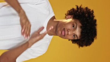 Dikey video. Reddetme jesti. Başparmaklar aşağı. Memnuniyetsiz adam kollarını kavuşturuyor. Onaylamama kısıtlaması var. Sarı arka planda izole edilmemiş..