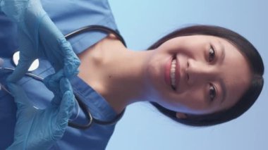 Dikey video. Dost canlısı doktor. Kalp hareketi. Destekleyici, neşeli, el ele tutuşan kadın sağlık hizmetleri gönüllüsü sembolü sevgiyi gösteriyor..