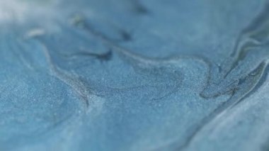 Parıltı akıyor. Odaklanmış sıvı emülsiyon. Bulanık mavi renk parıltılı desen boya karışımı sıçrayan dalga hareketli soyut sanat arkaplanı.