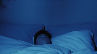 Kötü bir rüya. Gece dehşeti. Uyku korkusu. Korkmuş bir adam, karanlık yatak odasındaki şeytani el gölgesi kâbusundan uyandı..