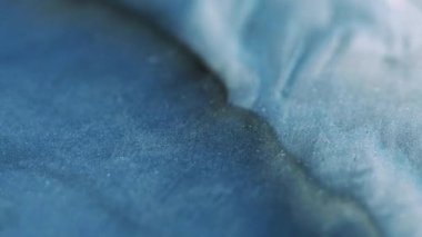 Dalga hareketi. Köpüklü sıvı. Işıldayan parlak mavi sıvı parlayan parçacıklar hipnotik soyut sanat arka planında parlak doku akışı.