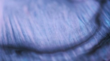 Parıltı dalgası. Boya suyu akışı. Odaklanmamış mor renk parıldayan parlak doku sıvısı dökülmesi soyut sanat arkaplanı.