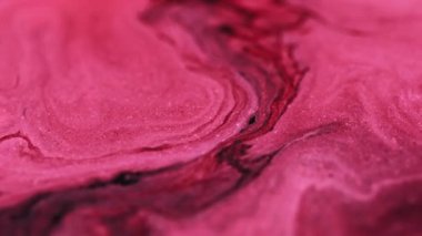 Parlak bir geçmişi var. Parıltı akıyor. Parlak kırmızı desen kırmızı pembe siyah pigment parıldayan parçacıklar hareket soyut sanat emülsiyonu.