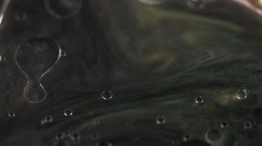 Yağ damlaları boya. Parıldayan mürekkep. Odaklanamayan siyah altın rengi yüzen şeffaf kabarcıklar parlak parçacıklar parıldayan emülsiyon hareketi soyut sanat arka planı.