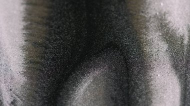 Parıldayan mürekkep. Parıltılı boya. Bulanık siyah gümüş rengi, ışıl ışıl parlayan parçacıklar, lüks sıvı dokular, soyut sanat arkaplanı..