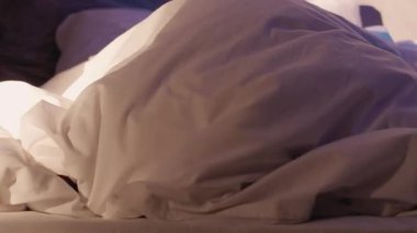 Gece nöbeti. Gizli online sohbet. İtaatsiz genç adam, ebeveyn kontrolünden gelen telefonla battaniyenin altında saklanıyor..