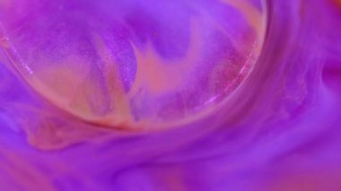 Mürekkep karışımı. Parıltılı boya. Odaklanmamış mor turuncu renk kıvrımlı parlak jel parlak sis parıldayan emülsiyon hareketi soyut sanat arka planı