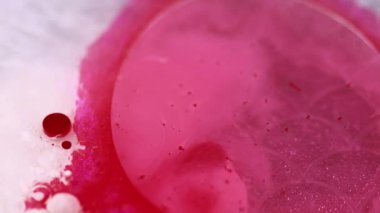 Parlak mürekkep. Boya sıçraması. Işıldayan sıvı. Odaklanmamış pembe beyaz gümüş rengi lüks jel yağ kabarcıkları ıslak parlak doku soyut sanat arkaplanı.