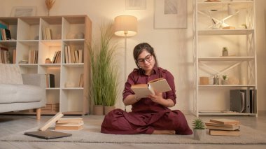 Yoga kitabı. Boş vakitleri değerlendiriyorum. Sıcak bir hafta sonu. Hayalperest barışçıl kadın evde, oturma odasında dinlenirken ilginç meditasyon edebiyatının keyfini çıkarıyor..