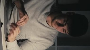 Dikey video. Masa uyuyor. Son teslim tarihi yorgunluğu. Tembel gece. Çok çalışan kafası karışmış bir iş adamı masada uyukluyor. Laptopunu açıyor. Koyu renkli ev ofisinde çay içiyor..