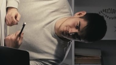 Dikey video. Sanal brifing. Geç iletişim. Laptop bağlantısı. Kendine güveni tam bir iş adamı. Gece online toplantı yapıyor. Karanlık ofiste danışmanlık yapıyor..