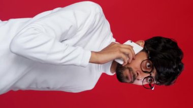 Dikey video. Sinir bozucu bir telefon görüşmesi. Mobil çatışma. Hoş olmayan bir konuşma. Rahatsız iş adamı anlaşmazlık gösteriyor. Kırmızıda izole yok diyor..