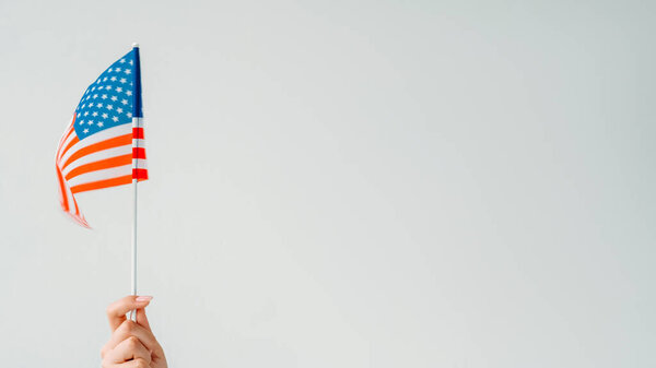 Флаг США. День независимости. Женская рука машет американским национальным символом с красными белыми полосками 50 звезд на голубом изолированном нейтральном фоне пустого пространства.
