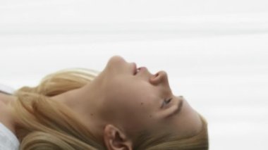 Dikey video. Sabah başlıyor. Motivasyon anı. Gün ışığı enerjisi. Olumlu, sakin bir kızın perdeleri açması, gülümsemesi, ferahlatıcı düşüncelere dalması, pencereden bakması..