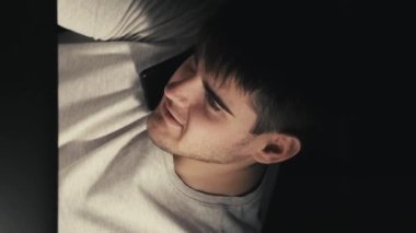 Dikey video. İş görüşmesi. Gece tartışması. Profesyonel konuşma. Kendine güveni tam bir serbest çalışan. Telefonla konuşuyor. Bilgisayarda daktilo yazıyor..