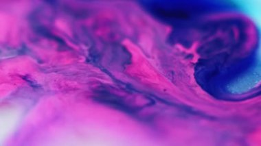 Parlak sıvı karışımı. Boya dökülmüş. Odaklanmamış pembe renk parıldayan parçacıklar sıvı emülsiyon akış hareketini soyut sanat arka planı.