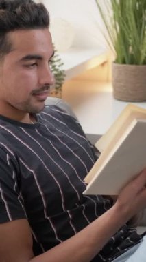 Dikey video. Kitap araştırması. Eğitim okuması. İlginç, sıradan bir adam evde oturup ilginç edebiyattan bilgi öğreniyor..