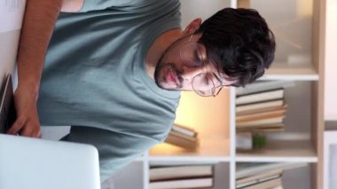 Dikey video. İnternet işi. Uzaktan kumandalı. İnternet araştırması. Modern iş yerinde bilgisayarla çalışan düşünceli, zeki bir adam..