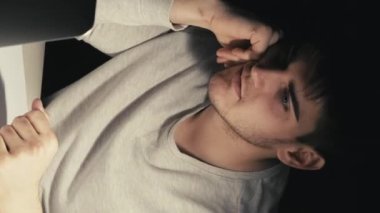 Dikey video. Çevrimiçi bilgilendirme. Gece tartışması. İş kararlılığı. Çalışkan, üretken girişimci bir adam karanlık ofiste danışmanlık hakkında konuşuyor..