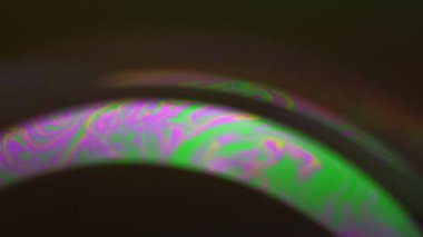 Renk karışımı. Psikedelik boya. Pembe, parlak, yeşil yağ kabarcığı sıvısı koyu siyah soyut sanat arka planında holografik eğri içinde harmanlanır..