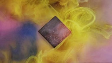 Renk dumanı. Suyu boya. Soyut sarı sis akışı parlak gökada kübü, yıldızlı dokuları, girdapları, mürekkep hareketlerini, mavi parıltılı arkaplanı ortaya çıkarıyor..