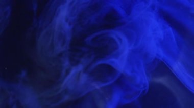 Bulanık sis bulutu. Boya suyu sıçraması. Odaklanmamış mavi renkli, parlayan toz parçacıkları koyu siyah soyut sanat arka planında yüzen sis dokusu..