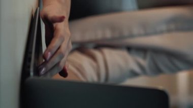 Dikey video. Laptop tipi. Online eğitim. Tanımlanamayan bir kadın bilgisayar tuşuna basarak bilgi topluyor ve öğrenci araştırmaları hakkında notlar alıyor..