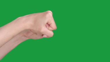 Dikey video. İlk tehdit. Boks jesti. Protesto dövüşü. Yeşil renkli anahtar boş arkaplanda izole edilmiş elleri sımsıkı bağlı kadın uyarısı.