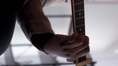 Dikey video. Gitar şarkıcısı. Müzikal hobi. Şarkı eğlencesi. Telli akustik enstrüman çalan neşeli yetenekli adam evde ses egzersizi yapıyor..