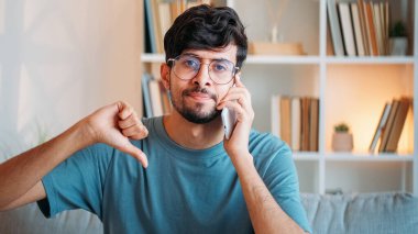 Gezici hayal kırıklığı. Haberler kötü. Olumsuz iletişim. Memnuniyetsiz üzgün adam telefonda konuşuyor. Reddettiğini gösteriyor. Ev içi boş alana sahip baş parmak hareketi yok..