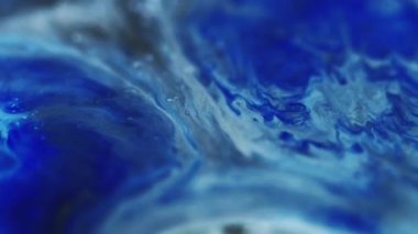 Mürekkep dalgası. Parıldayan sıvı dökülmüş. Odaklanmamış mavi renk tanecikleri dokusu sıvı akış hareketi soyut sanat arkaplanı.