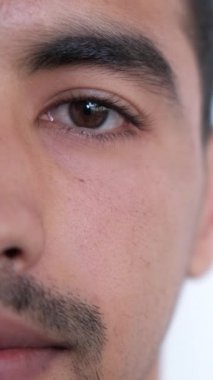 Dikey video. Görüş düzeltmesi. Vizyon ilacı. Oftalmoloji kliniği. Sakin bir adam, yarım yüz portresi, sağlıklı kahverengi göz rengi..