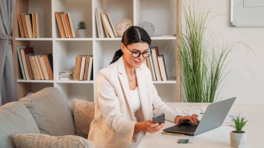 Güzel sohbetti. Zarif kadın. İnternet teknolojisi. Mutlu iş kadını bilgisayarlı mesajlaşmada çalışıyor. Akıllı telefon, ofisin içinde..