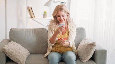 Arzu edilen hamilelik. Mutlu kadın. Haberleri paylaşıyoruz. Kanepenin iç tarafındaki koltukta oturan bayanın pozitif test sonuçlarını çekmesi ilham verici..