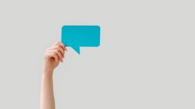 Mesaj balonu. Mesaj modelimiz. Sosyal medya iletişimi. Mavi boş diyalog simgesini tutan kadın eli boş arkaplanda izole edildi.