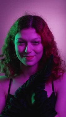 Dikey video. Kötü kadın. Kurnaz gülümseme. Güzel, büyüleyici kadın entrikaları. Siyah eldivenler. Akşam elbisesi..