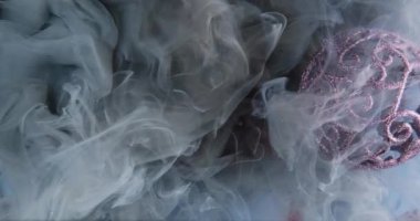 Noel büyüsü. Sigara arkaplanı. Pırıl pırıl, mor, pırıl pırıl gri bir sis bulutu kırmızı parıldayan parıltılı doku yüzeyine yayılıyor..