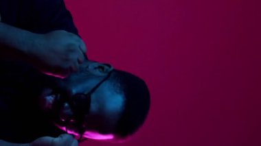 Dikey video. Zafer sevinci. Kutlamayı kazan. Tuhaf bir ruh hali. Mutlu, heyecanlı, komik adam piyango başarısıyla tatmin olmuş, çığlık çığlığa evet diye bağırıyor, şarap rengi arka planda izole bir şekilde dans ediyor..